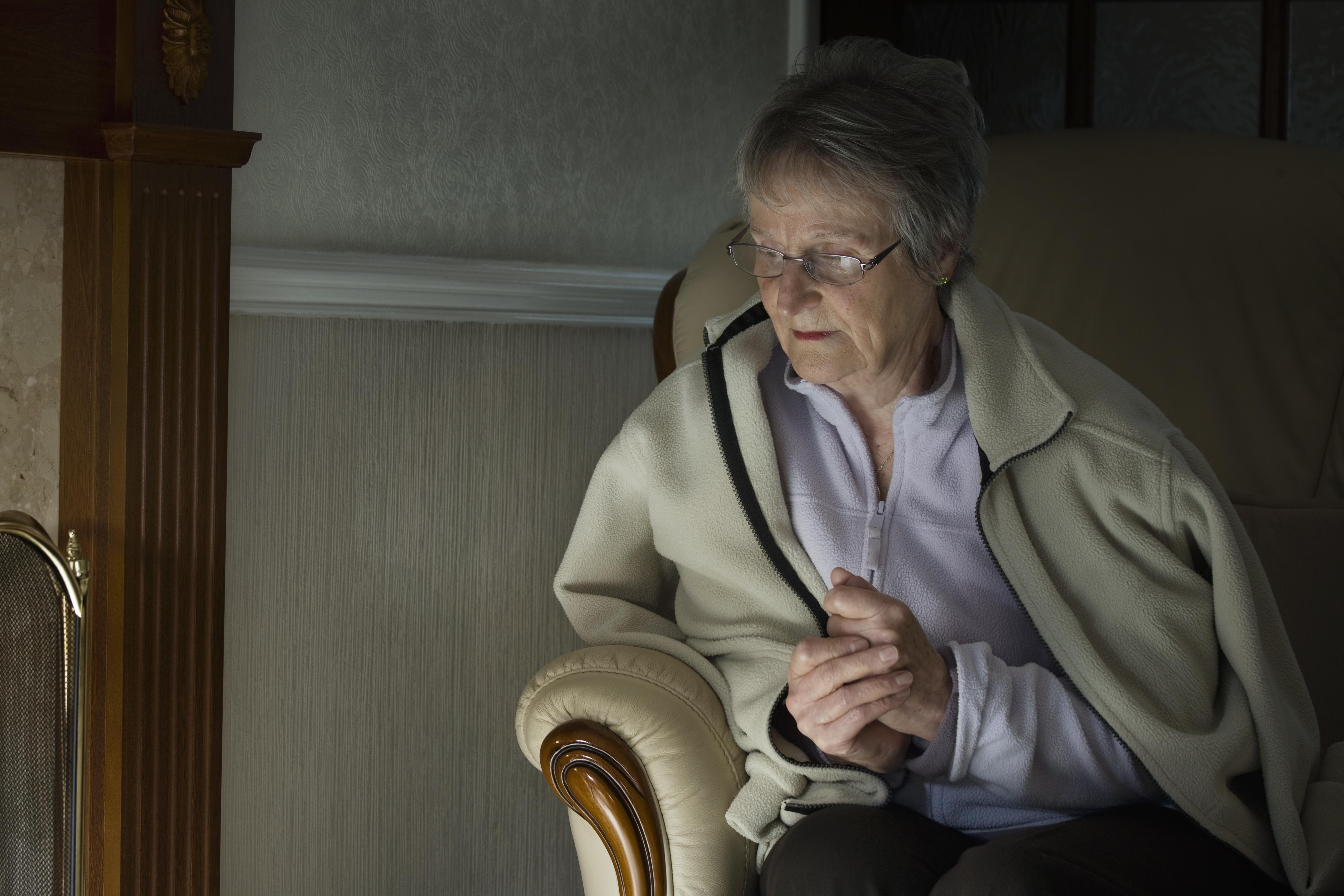 Elderly woman waring extra layers and looking cold