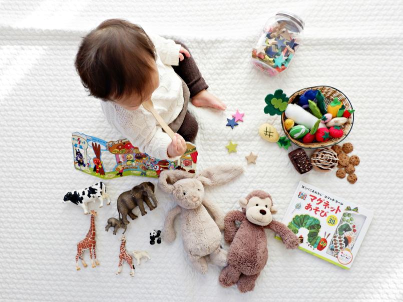 Baby on a rug surrounded by toys