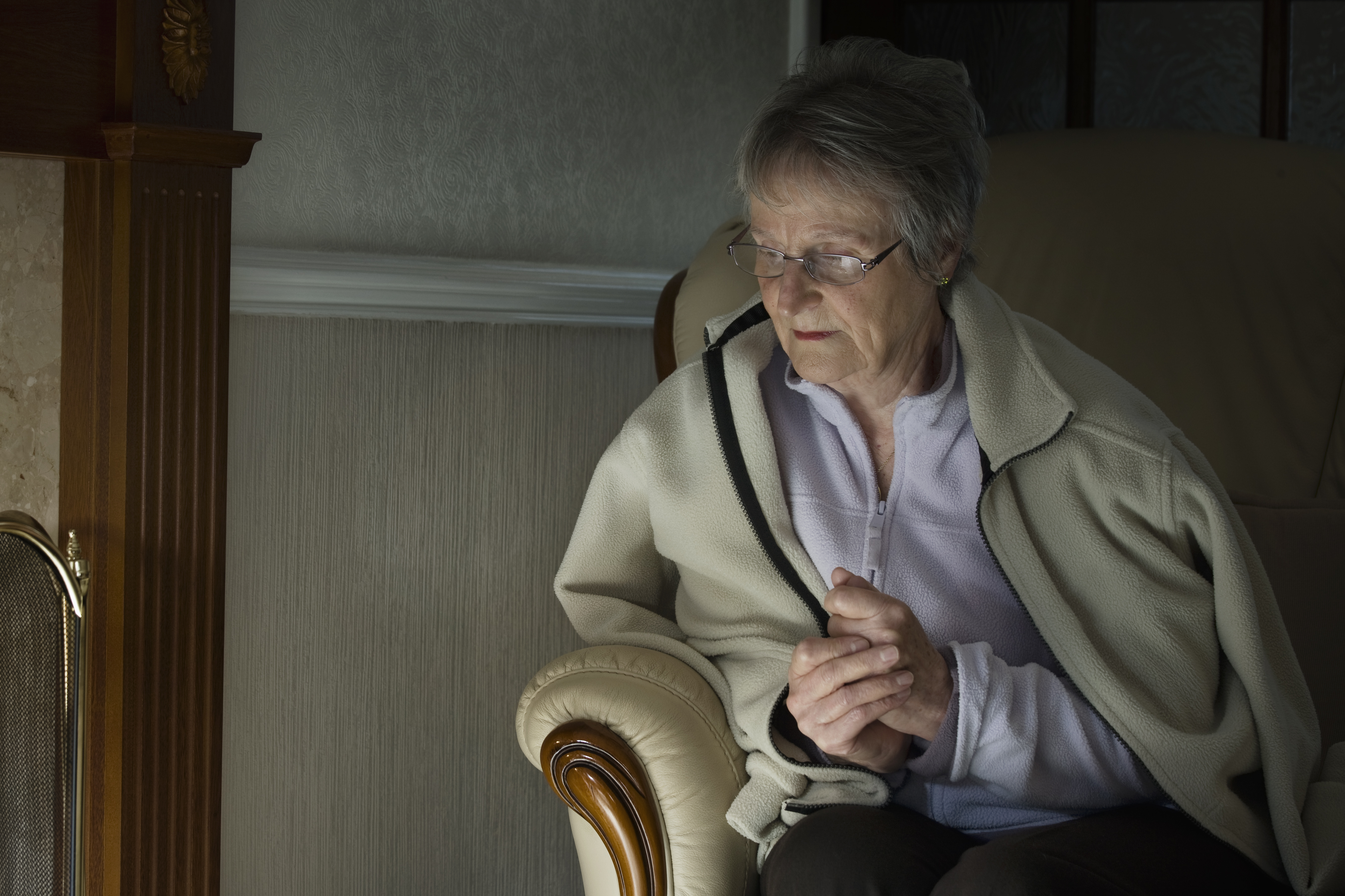 Picture of an elderly woman keeping warm in a house.