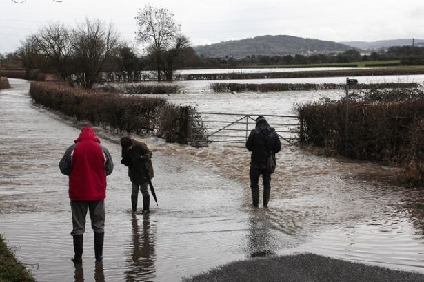 Three people wading on country road flooded by River Severn FOE EWNI/Quentin Given