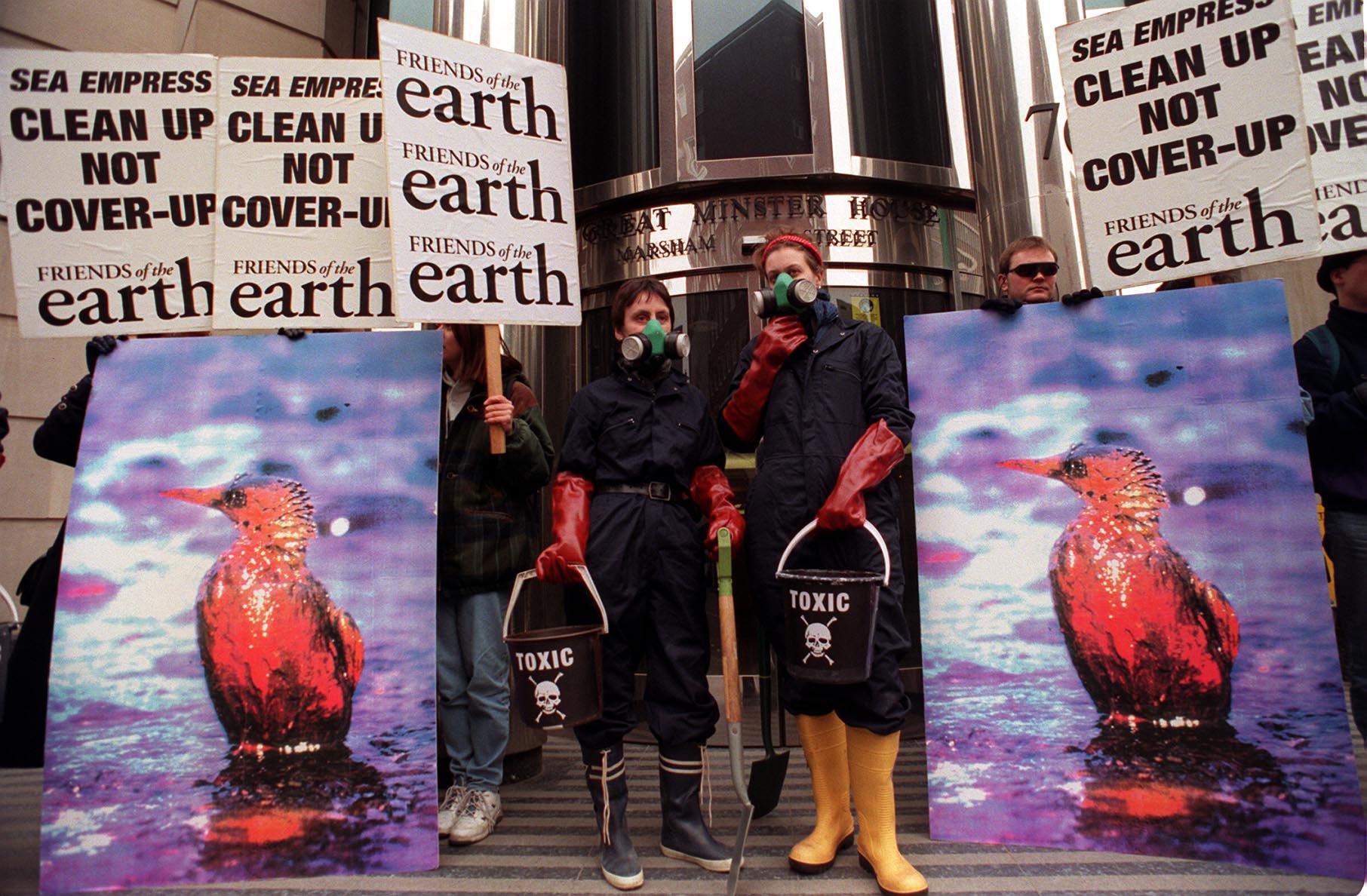 People holding posters clean up sea empress and high pictures of affected birds