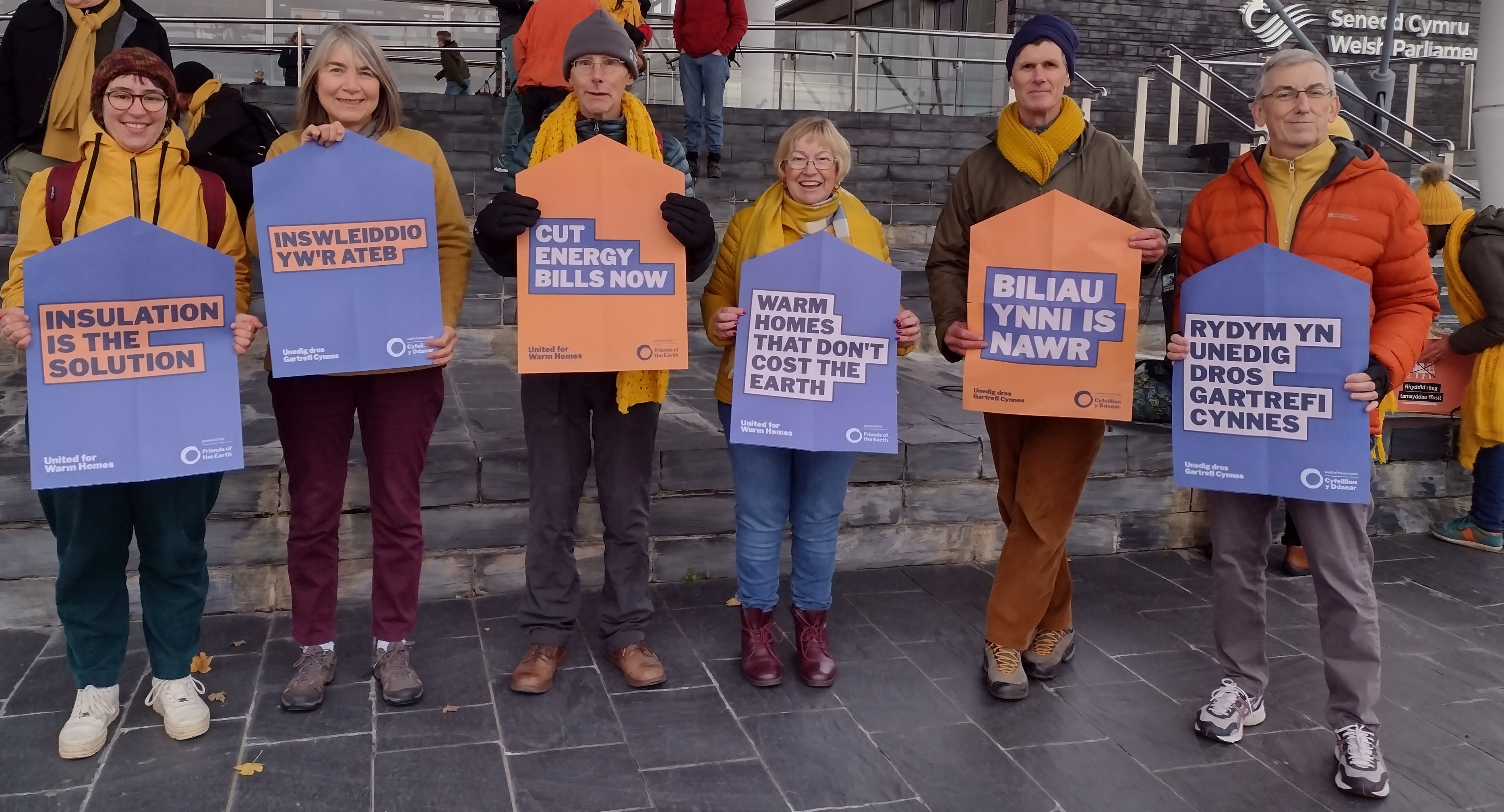 People standing outside Senedd holding placards