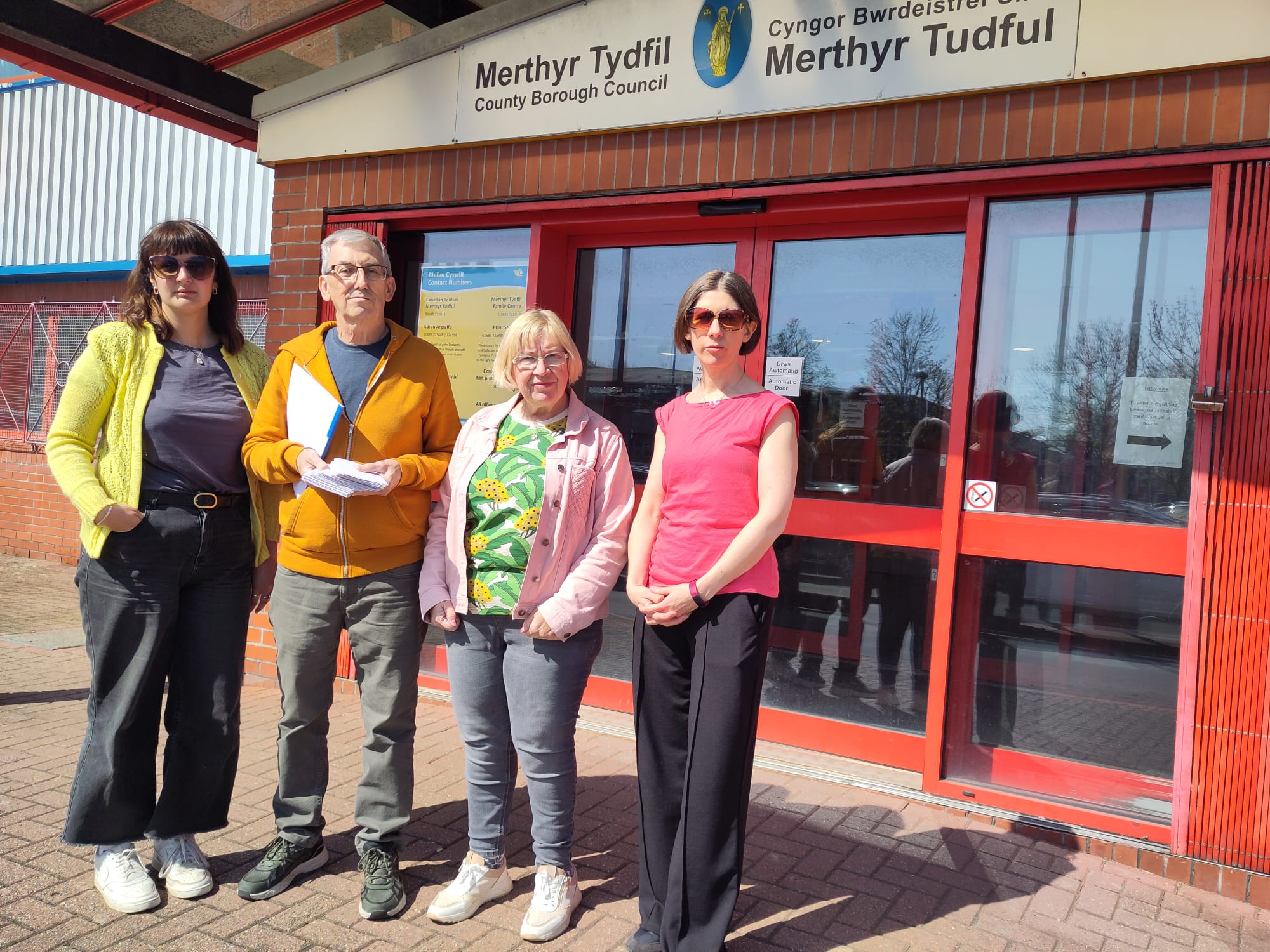 four people standing outside Merthyr Council offices