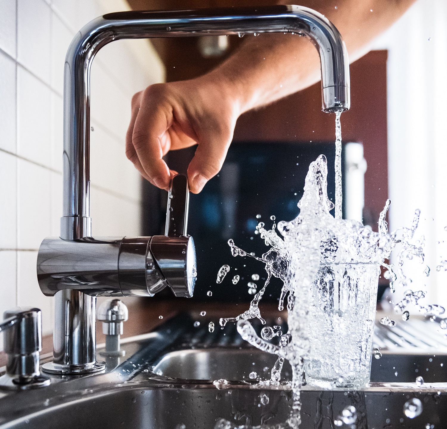 Someone turning on a kitchen tap