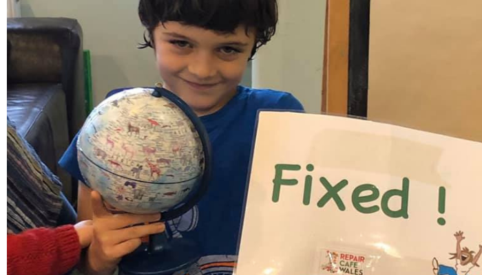 Picture of a boy, a toy globe and a sign saying 'fixed'