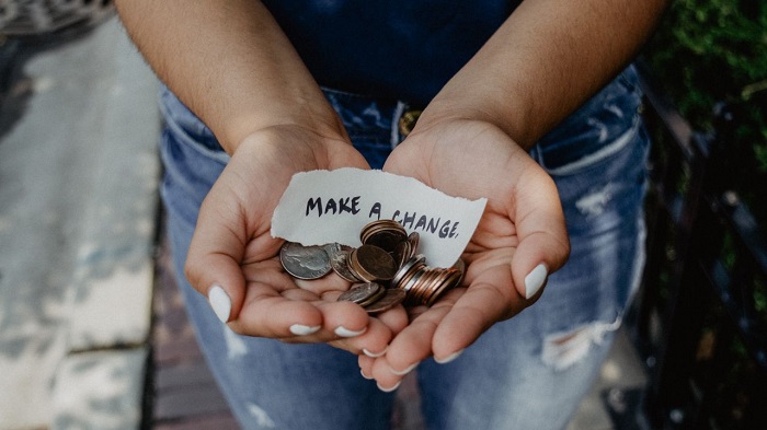 Picture of someone holding coins and a make a change note.
