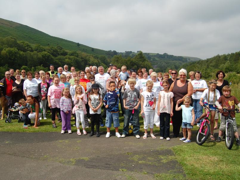 Group photo of campaigners against the incinerator with hills in the background/Llun grŵp o ymgyrchwyr yn erbyn y llosgydd gyda bryniau yn y cefndir