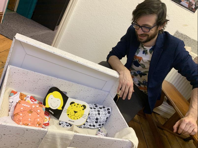 Man looking into a baby box
