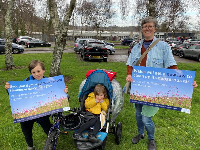 Mother and son each hold a poster entitled, 'Wales will get a new law to clean up its dangerous air'