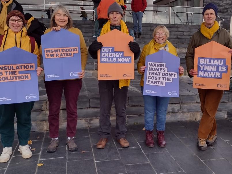 People standing outside the Senedd holding placards