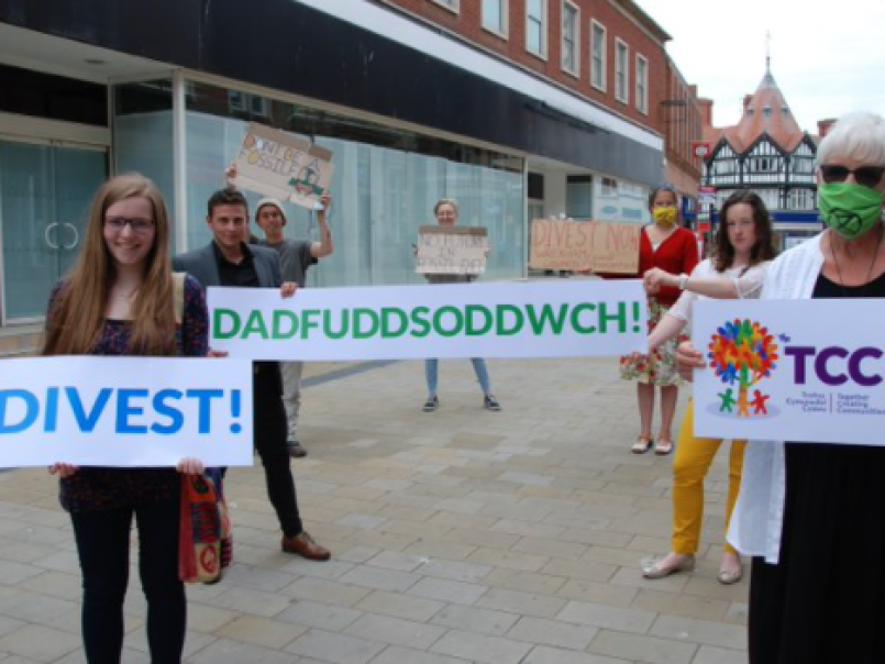 Picture of three people holding divest placards