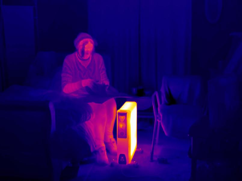 Thermal image of a woman trying to keep warm in her house
