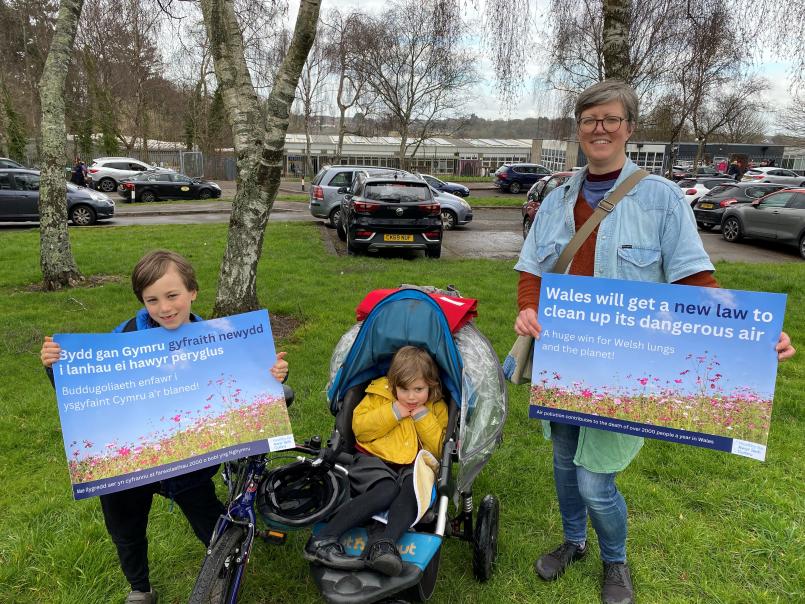 Picture of woman with her two children holding a poster entitled 'Wales will get a new law to clean up its dangerous air'