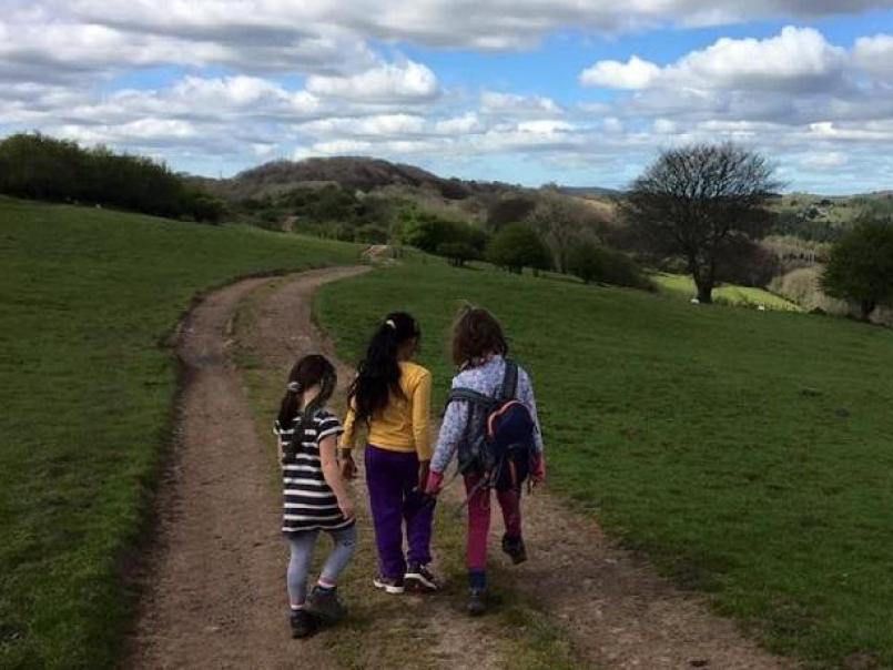 Picture of three children walking in the hills under a blue sky