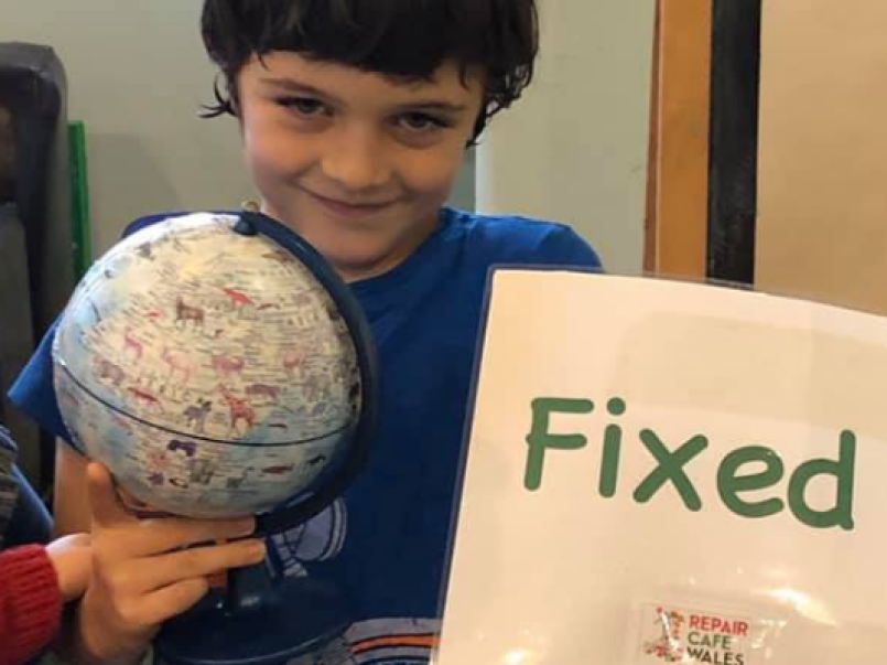 Photo of a child holding a globe and fixed sign