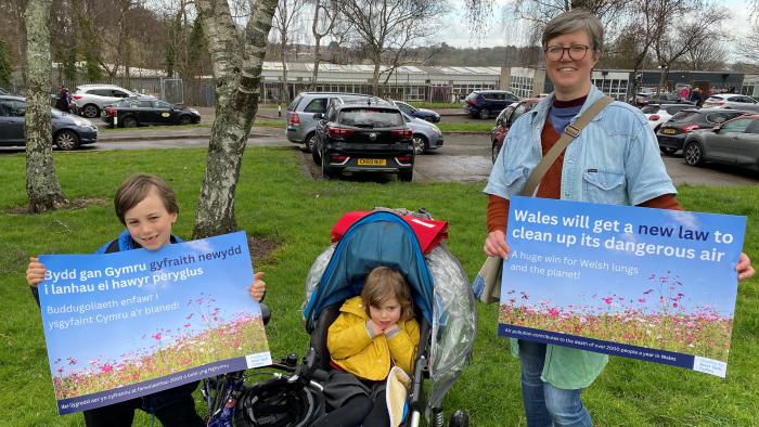 Picture of woman with her two children holding a poster entitled 'Wales will get a new law to clean up its dangerous air'